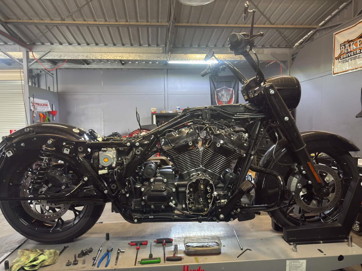 A Harley stripped down on the hoist at Kidd Motorcycles